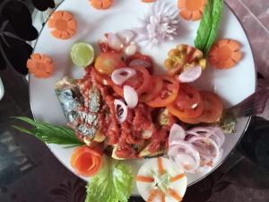 a plate of food with tomatoes and vegetables on it at Mahee house in Hiriketiya