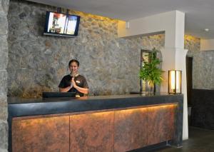 a man standing behind a counter in a lobby at Grand Southsea Khaolak Beach Resort in Khao Lak +45 photos