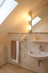 a bathroom with a sink and a mirror at Pension Weindl in Notzing