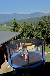 two children are playing on a trampoline at Heideggerhof in Bolzano