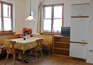 a kitchen with a table and chairs and a kitchen with a television at Heideggerhof in Bolzano