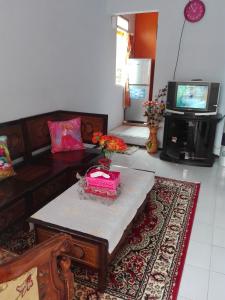 sala de estar con sofá y TV en Homestay Andari, en Batu
