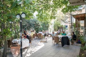 a group of people sitting at tables in a garden at Berksoy Hotel in Bergama
