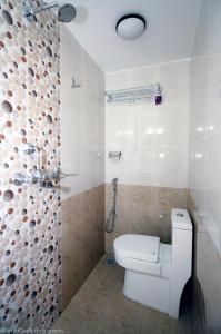a white bathroom with a toilet and a shower at Yeti Inn Pvt. Ltd. in Kathmandu
