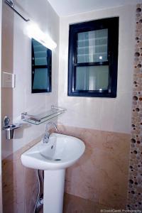 een badkamer met een witte wastafel en een raam bij Yeti Inn Pvt. Ltd. in Kathmandu