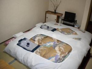 a bed with a bath tub on it at Mimatsuso Ryokan in Asahikawa