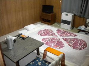 a room with a table and a bed with an umbrella at Mimatsuso Ryokan in Asahikawa