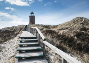a staircase leading to a lighthouse on a beach at Weisse Düne - App. 3 in Wenningstedt