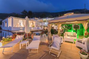 a patio with chairs and umbrellas at night at B&B Villa Cristina in Anacapri