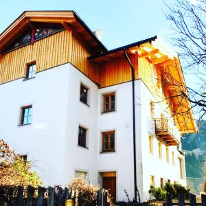 a white house with a wooden roof at Seebacher Apartments in Sarntal