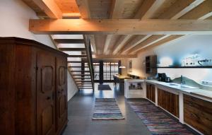 a large kitchen with wooden ceilings and a staircase at Marchlhof in Aschau im Chiemgau
