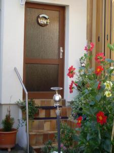 een houten deur met een areath erop naast enkele bloemen bij Ferienwohnung Langenhecke 16 in Bad Münstereifel