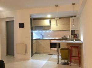 a kitchen with wooden cabinets and a table and chairs at Apartamento Oteiza in San Sebastián