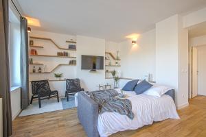 a bedroom with a bed and two chairs and a desk at Port de Caen Haut de Gamme in Caen