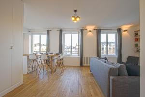 a living room with a couch and a table with chairs at Port de Caen Haut de Gamme in Caen