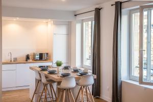 a kitchen with a wooden table and stools in a room at Port de Caen Haut de Gamme in Caen +21 photos