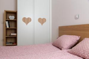 1 dormitorio con 1 cama con corazones en la pared en Auredius Deluxe Apartment en Kranjska Gora