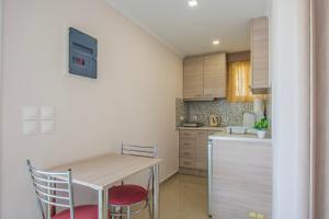 a kitchen with a table and two chairs and a counter at Dennis Tsilivi Houses & Studios by "elite" in Tsilivi