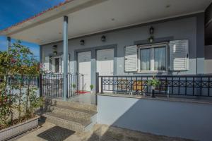 ein Haus mit Balkon mit Fenstern und Pflanzen in der Unterkunft Dennis Tsilivi Houses & Studios by "elite" in Planos