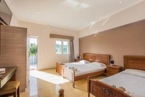 a bedroom with two beds and a balcony at Dennis Tsilivi Houses & Studios in Tsilivi