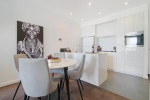 a kitchen and dining room with a table and chairs at ★Lux 2BR on Hindmarsh SQ★ in Adelaide
