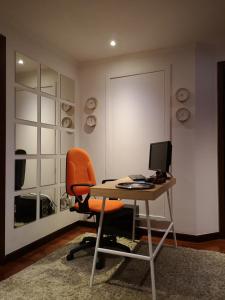 an orange chair sitting at a desk with a computer at AL embaixador in Alenquer