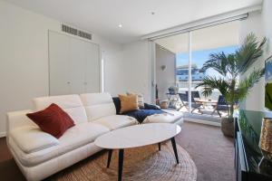 a living room with a white couch and a table at ★Lux 2BR on Hindmarsh SQ★ in Adelaide