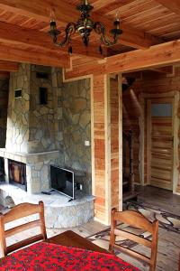 Cabaña con sala de estar con chimenea de piedra. en Noclegi Urbaniak, en Tylmanowa