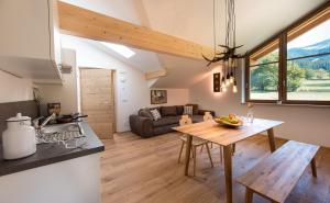 Casa con cocina y sala de estar con mesa de madera. en Seebacher Apartments, en Sarentino