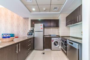a kitchen with a refrigerator and a dishwasher at Icon Casa Living - Bay Central Tower in Dubai