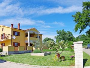 a yellow house with a bike in the yard at Premium Apartment in Barban with Private Pool in Šajini