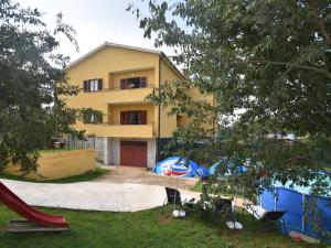 a yellow house with a slide and a playground at Premium Apartment in Barban with Private Pool in Šajini