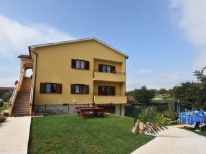 a yellow house with a picnic table in the yard at Premium Apartment in Barban with Private Pool in Šajini