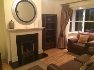 a living room with a mirror over a fireplace at ArdMullen Townhouse X Davitt's Guesthouse & Restaurant Kenmare in Kenmare