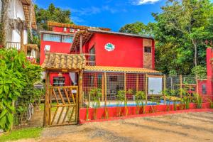 a red house with a fence and a pool at i9 Embaú Flats & Suites in Itacaré