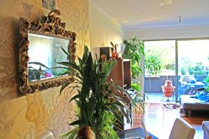 un soggiorno con specchio e pianta di Rochas Shared Apart Garden Refuge a Funchal