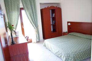 una camera da letto con un letto, un armadio e una finestra di Hotel Felix a Scalea Altre 37 foto