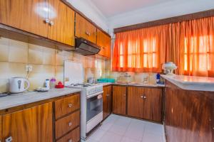 a kitchen with wooden cabinets and a stove top oven at Dennis Tsilivi Houses & Studios by "elite" in Tsilivi