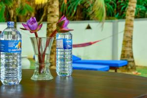 two bottles of water and a vase with flowers on a table at Oriental Rest in Hikkaduwa