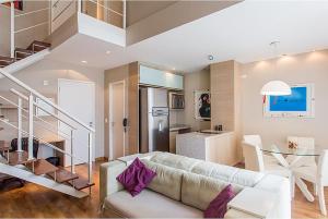 un soggiorno con un divano e una scala di Duplex NYC Berrini 2 dormitórios - ao lado do WTC a San Paolo