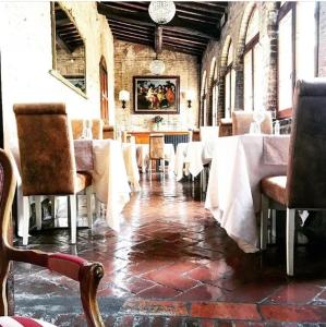 a dining room with white tables and chairs in a building at B&B Osteria Del Vicario in Certaldo