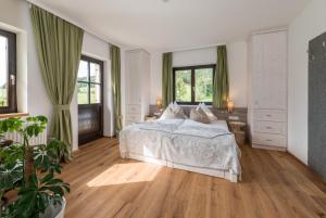 sypialnia z białym łóżkiem i zielonymi zasłonami w obiekcie Naturchalet Höflehner - Heimgefühl & Ruhelage an Loipe & Wanderweg w mieście Ramsau am Dachstein