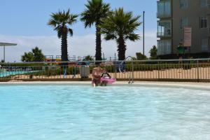 a man in a swimming pool with a pink frisbee at Laguna vista 903 in Algarrobo
