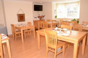 une salle à manger avec des tables et des chaises en bois dans l'établissement Pinewood House, à Whitby