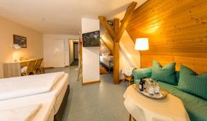 ein Hotelzimmer mit einem Bett und einem Sofa in der Unterkunft CityHotel Kempten in Kempten