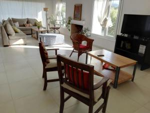 a living room with a couch and a table and chairs at Villa Clarita Tandil in Tandil +8 photos