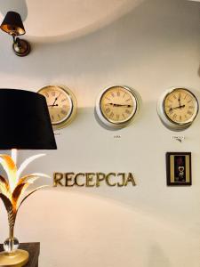 trzy zegary na ścianie ze słowem recederaria w obiekcie Gołąbek Łeba w Łebie