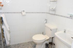 a white bathroom with a toilet and a sink at Pinewood House in Whitby