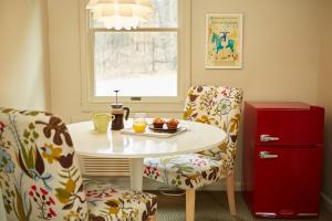 a table and two chairs with a plate of food on it at The Briarcliff Motel in Great Barrington