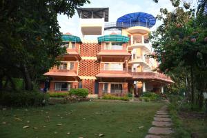 un grande edificio con un prato davanti di Shree Ramkrishna Anandvan a Ratnagiri